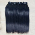Three bundles of straight black human hair extensions laid out on a surface.